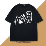 T-shirt unisexe noir avec anime chat blanc aux yeux grands et bouche ouverte avec texte japonais couleurs tendance
