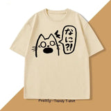 T-shirt unisexe crème avec anime chat noir aux yeux écarquillés et texte japonais sur bulles de parole couleurs tendance
